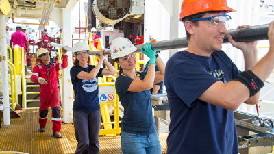 IODP crew and Co-chief Scientists Lisa McNeill and Brandon Dugan help carry the last core.